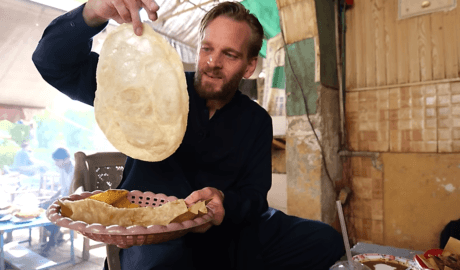 Man holding large piece of bread in pakistan karl rock