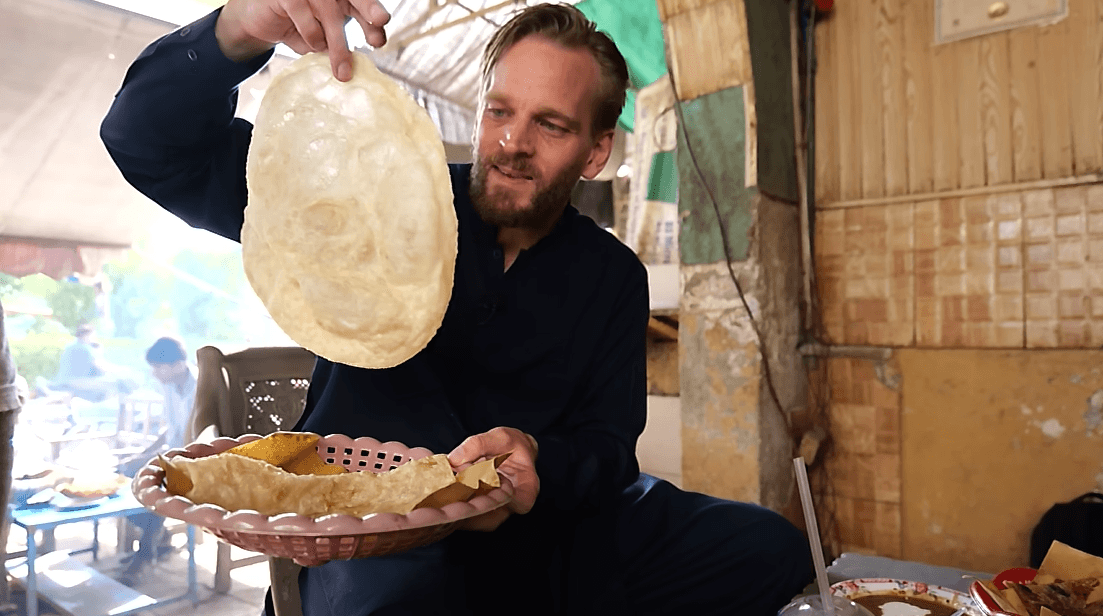 Man holding large piece of bread in pakistan karl rock